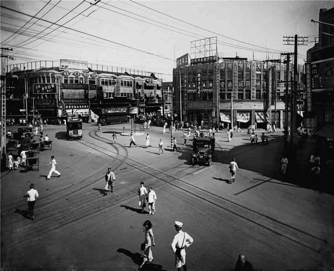 20世纪30年代，上海老城厢老西门路口行人、黄包车、汽车和有轨电车穿梭的景观。